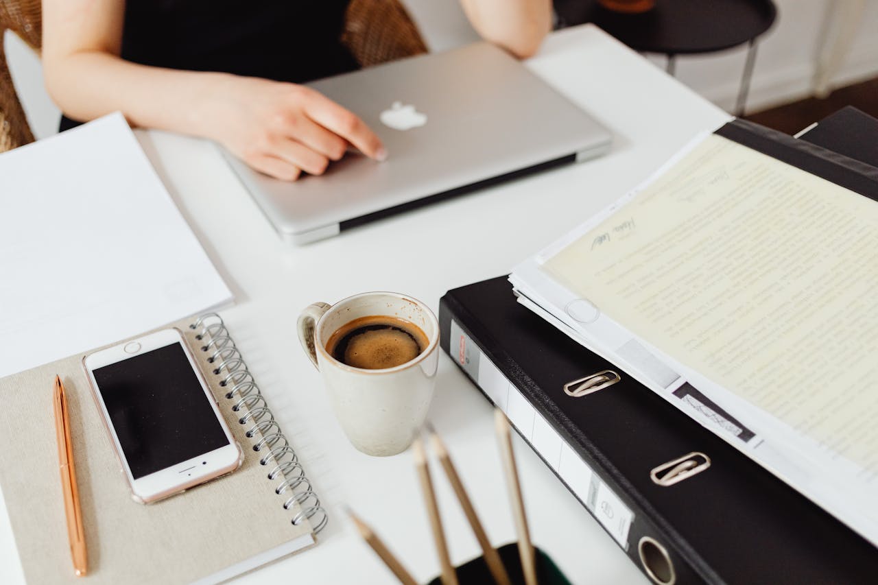 gallery-1 A clean workspace featuring a laptop, coffee, smartphone, and documents for efficient work.