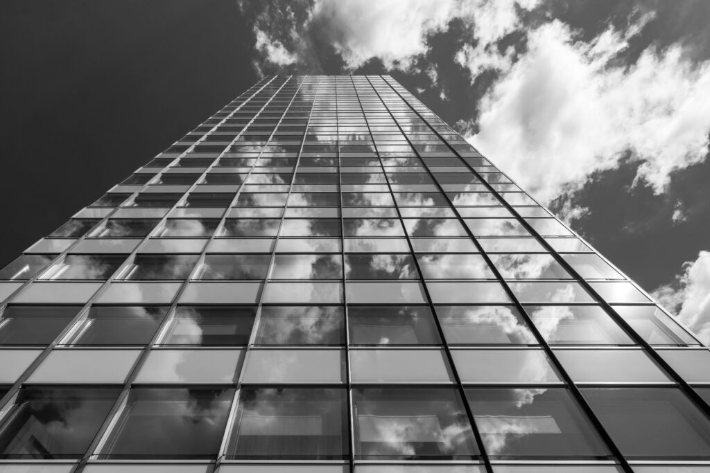 Black and white view of a modern skyscraper reflecting clouds in Hamburg, Germany.